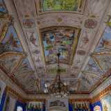 In alto un�elaborata cornice perimetrale rossa e dorata lascia spazio all�incantevole volta a padiglione. Una fascia a lunette trilobate, affiancate da figure angeliche, circonda l�ampio riquadro centrale che rappresenta una scena di guerra civile dell�antica Roma 